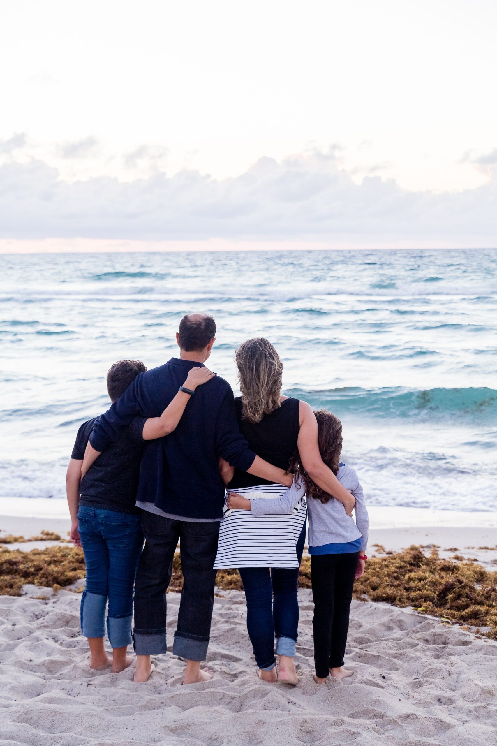 family of four standing looking out at ocean